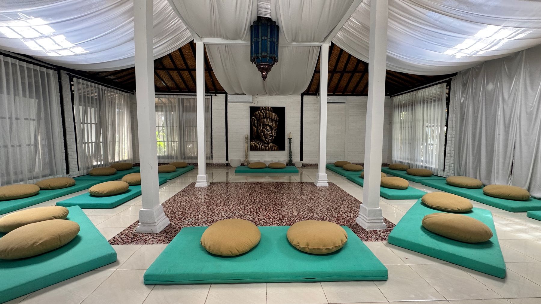Shivatri Temple, a white space inside the main house with pillars, draped ceiling and floor cushions